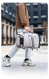 Detail view of a large grey travel backpack with multiple zip pockets and reinforced handles