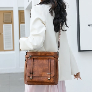 Vintage brown leather crossbody bucket bag with flap cover and woven wide strap