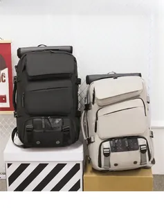 Detail of multi-pocket travel backpacks in black and beige with roll-top and buckles