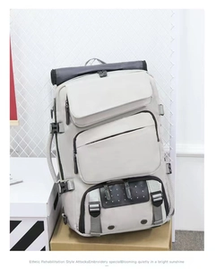 Light grey multi-pocket travel backpack showing durable nylon texture and layered zippers