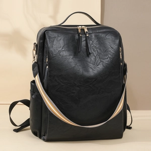 Detail eines schwarzen PU-Rucksacks mit gestreiftem Webgurt und Metallreißverschluss
