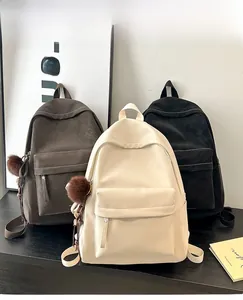 Detailed view of PU leather backpacks in dark brown, cream, and charcoal with fur charms