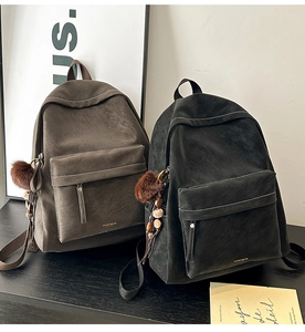 Detail view of vintage PU leather backpacks with contrast stitching and decorative pendants
