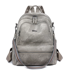 Detailed front view of gray vintage multi-pocket backpack with colorful woven strap