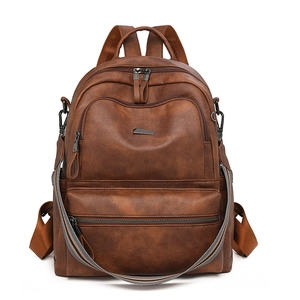 Detail view of brown vintage PU leather backpack with colorful striped shoulder strap
