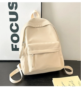 Detail of cream PU leather backpack featuring front flap pocket and Keddybear logo