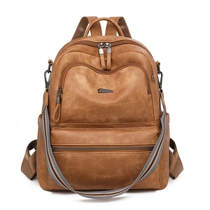 Detail view of brown PU leather backpack featuring stripe woven straps and metal hardware