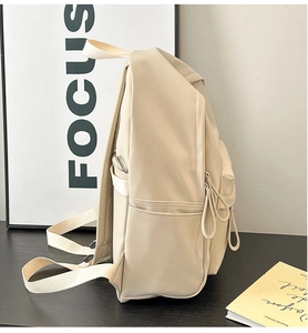 Detail view of the cream white PU backpack side pocket and smooth matte leather texture