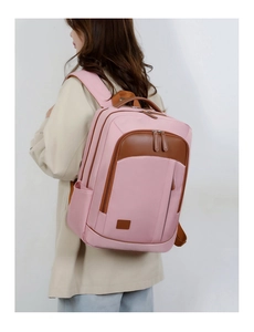 Pink and brown patchwork backpack with padded straps shown on a model in a beige coat