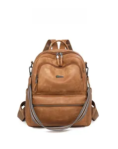 Front view of brown leather backpack featuring a striped woven shoulder strap and zipper pocket