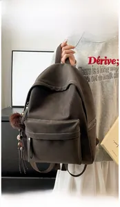 Detail of dark brown faux suede backpack with contrast stitching and tassel charm