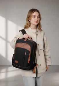Business backpack with USB charging port and brown leather details on black fabric