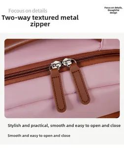 Detail of pink backpack featuring dual metal zippers with premium brown leather pullers