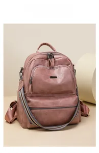 Detail of grey-pink PU leather backpack with striped strap and multi-pocket structure