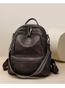 Detail view of brown vintage PU leather backpack with striped woven shoulder strap