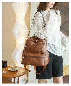 Brown vintage faux leather backpack for women shown in a lifestyle interior setting