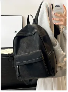 Detail of black PU leather backpack featuring white contrast stitching and gold lettering