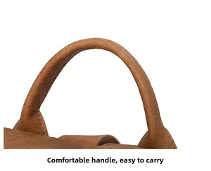 Detailed close-up of the reinforced brown pebble leather top handle and stitching