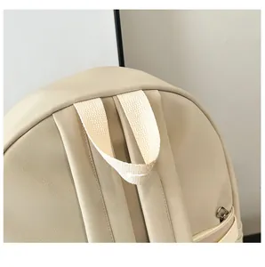 Detailed close-up of textured beige PU leather backpack handle and zipper stitching