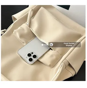 Detail view of beige PU leather backpack showing front zipper pocket with smartphone storage