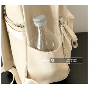 Detail view of the functional side pocket of a cream PU leather laptop backpack for women