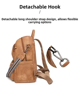 Detail of detachable metal hooks and striped shoulder strap on a vintage brown backpack
