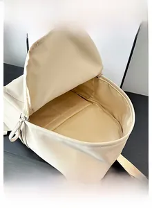 Detailed interior of a beige PU backpack showing a spacious compartment and silver zipper