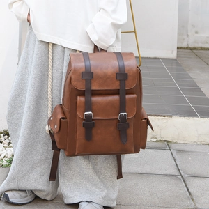 Close-up of vintage brown PU leather backpack with dual straps and magnetic buckles