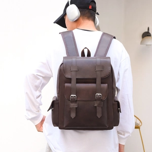 Detail of dark brown vintage PU leather backpack with silver metal buckles and front pocket