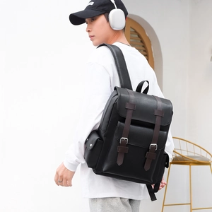 Detail view of black PU leather backpack featuring brown straps and silver metal buckles