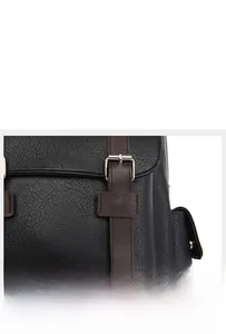 Detail of black lychee leather backpack showing silver buckle and brown trim strap