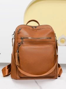 Detail of caramel PU leather backpack featuring litchi texture and stylish tassel charm