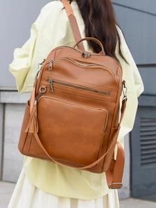 Detailed view of brown PU leather backpack with vintage texture and stylish tassel charm