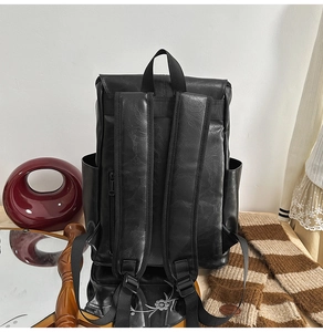 Detail of black PU leather backpack with pebble texture and functional back zipper pocket