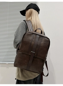 Detailed side-back view of a minimalist dark brown leather backpack for city commuting