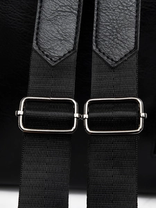 Close-up of black nylon shoulder straps with silver metal adjustment buckles and leather