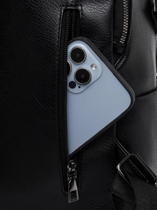 Close-up of anti-theft back zipper pocket on black leather backpack with blue smartphone