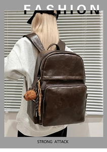 Macro detail of dark brown PU leather backpack texture with a cute teddy bear charm