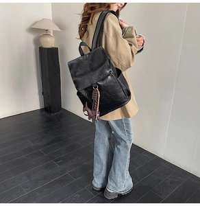 Minimalist black PU leather backpack with side pockets and a cute horse charm accessory