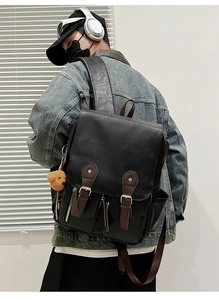 Detailansicht des schwarzen Vintage-PU-Lederrucksacks mit Doppelschnallen und Bärenanhänger