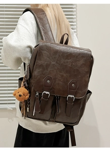 Detailansicht eines braunen Vintage-Rucksacks aus PU-Leder mit Teddybär-Anhänger