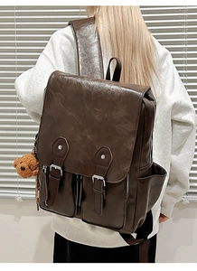Detailansicht dunkelbrauner Vintage-Rucksack aus PU-Leder mit Schnallen und Bärenanhänger
