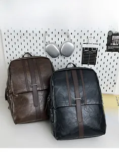 Detail of vintage PU leather backpacks in brown and black with metal buckle straps