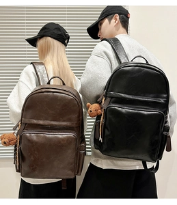 Rear view of couple wearing black and dark brown PU leather backpacks with bear charms