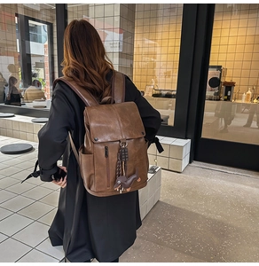 Outdoor shot of a vintage brown PU leather backpack with a cute dachshund charm