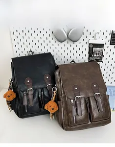 Detail von Vintage Lederrucksäcken in Schwarz und Braun mit Teddybär Anhängern