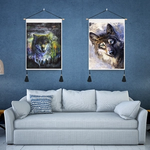 Detail of wolf tapestry wall art featuring wooden hanging rods and black silk tassels