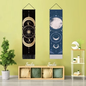 Detail view of moon phase wall tapestries with tassels in a cozy minimalist living room