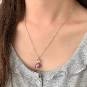 Élégant collier tulipe rose avec chaîne argentée porté sur le cou d'un mannequin