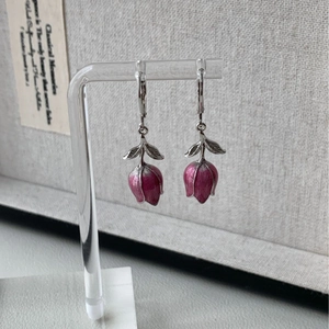 Élégantes boucles d'oreilles tulipes roses avec feuilles argentées sur support d'art